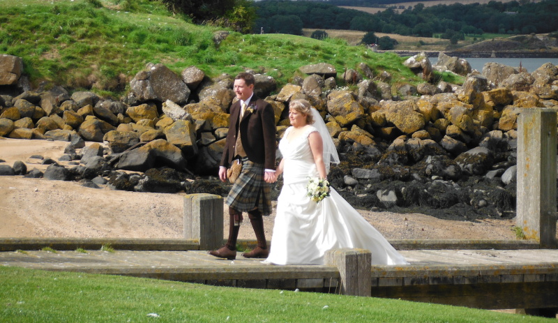  the bride and groom on the wooden jetty